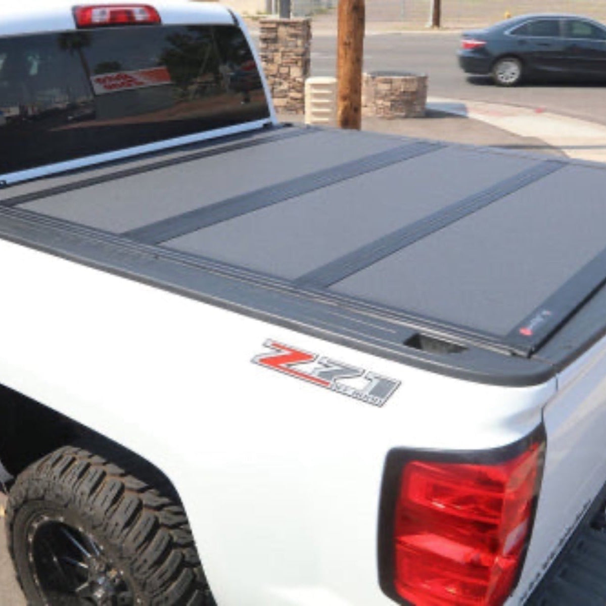 White truck with a low profile tonneau hard trifold cover sold by otsbedlinersdfw and installed near Frisco and McKinney, Texas.
